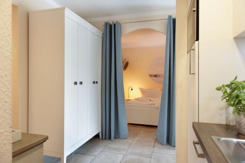a room with white cabinets and blue curtains at Fernweh in List
