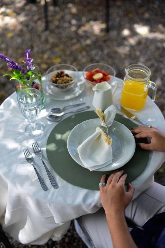 a woman sitting at a table with a plate of food at Casa Barichara Boutique in Barichara