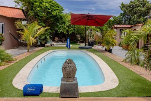 a swimming pool with a statue in front of a house at Aruba Casita in Noord