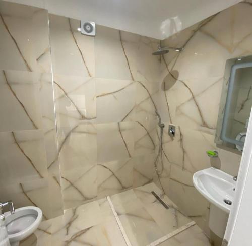 a bathroom with a sink and a toilet at Megi's apartment in Shëngjin