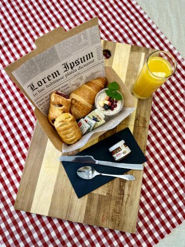 a wooden table with a box of food and a glass of orange juice at Numa Salzburg Ivy in Anif