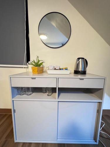 a white dresser with a mirror on the wall at Cozy Scandi Industrial House in San Pablo