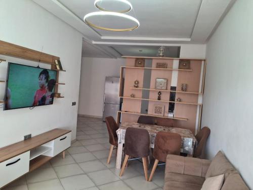 a living room with a dining room table and a television at البحر والشمس والطبيعه in Pont Blondin