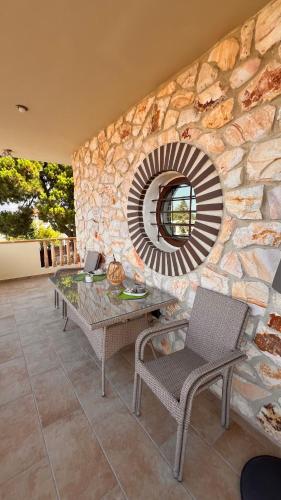 a stone wall with a table and a mirror at Heraklia villa sea view pool & jacuzzi in Nea Iraklia