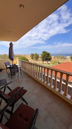 a balcony with a table and chairs and a view of the desert at Heraklia villa sea view pool & jacuzzi in Nea Iraklia