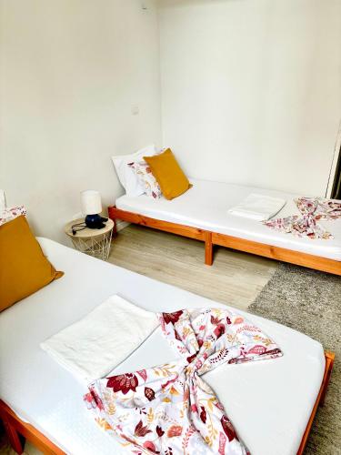 a room with two beds and a table at Ndussole Guest House in Porto