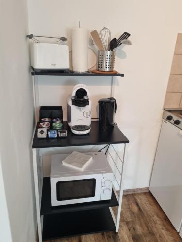 a shelf with a microwave on top of it at CJS Apartments - Chill or Drive am Nürburgring, Free Parking, WLan, Spacious Rooms, Quiet Location in Rodder
