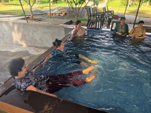 a group of people sitting in a swimming pool at Siva Rama garden resort & swimming pool 5star stay comfort 6BHK bheemili beach road nr in Visakhapatnam