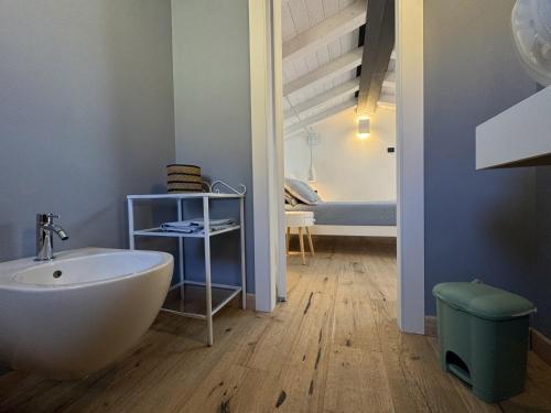 a bathroom with a tub and a sink and a bedroom at Casina di Nonna Meca by Solturelba in Capoliveri