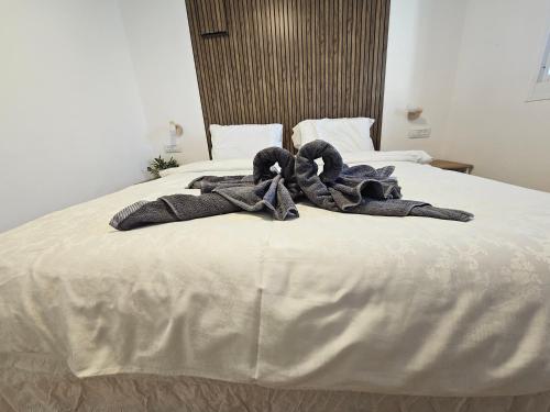 a bed with a pile of blankets on it at Zimmer Belev HaKikar- Dead sea in Neʼot HaKikar
