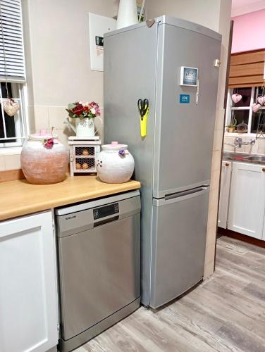 a kitchen with a refrigerator and a dishwasher at The Secret Garden Mossel Bay in Mossel Bay
