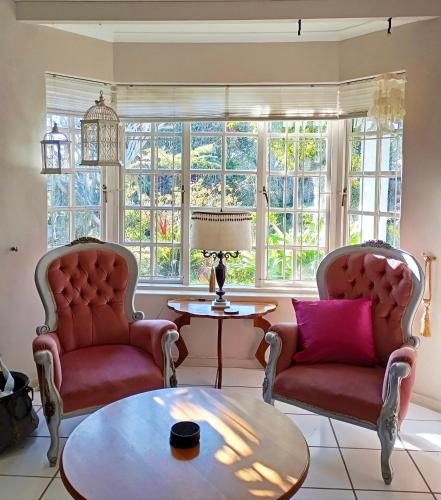 a living room with two chairs and a table at The Secret Garden Mossel Bay in Mossel Bay