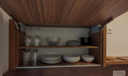 a cabinet filled with plates and bowls and glassware at Luxury Apartment Simba C in Smarjeske Toplice