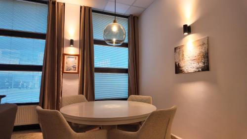 a table and chairs in a room with windows at Luxury Apartment Simba C in Smarjeske Toplice