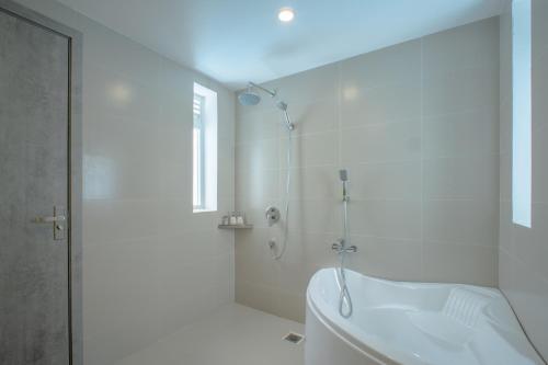 a white bathroom with a shower and a tub at The Up Hotel Phu Quoc Island - The Poolside Escape in Phu Quoc