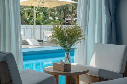 a living room with a table and a pool at The Up Hotel Phu Quoc Island - The Poolside Escape in Phu Quoc