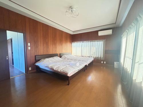 a bedroom with a bed in a room with wooden walls at Jun resort 梅-CB0103 in Kujukuri