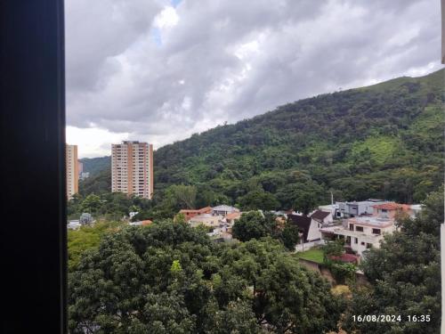 una città di fronte a una montagna con edifici e alberi di Alojamiento espectacular con respaldo de electricidad y agua constante 24 horas Venezuela Valencia a Valencia