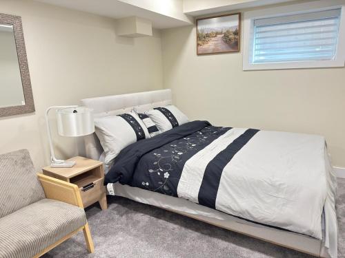 a bedroom with a bed and a chair and a window at Annas Suites Rental in Bélanger