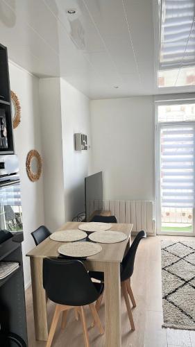 Un comedor con mesa y sillas de madera. en Appartement vue mer au cœur de Berck Plage, en Berck-sur-Mer