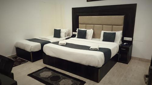 two beds in a hotel room with two at Hotel Kiara - Free Airport Drop Delhi Airport in New Delhi