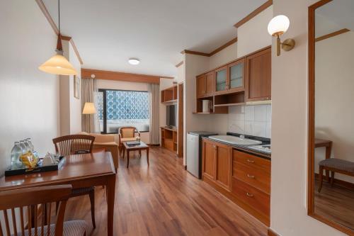 a kitchen and living room with a table and chairs at Grand Diamond Suites Hotel in Bangkok