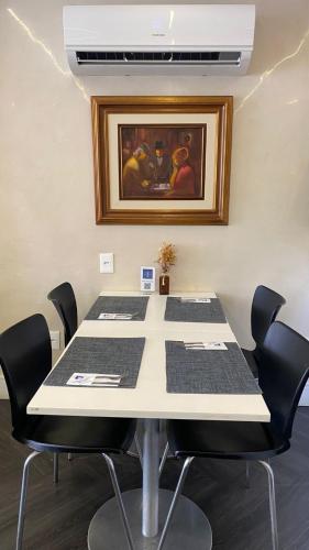 a conference room with a table with chairs and a painting at Camaçari Plaza Hotel in Camaçari