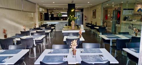 a dining room with white tables and chairs at Camaçari Plaza Hotel in Camaçari