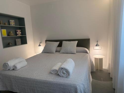 a white bedroom with a bed with towels on it at Piso GV 65 in Logroño
