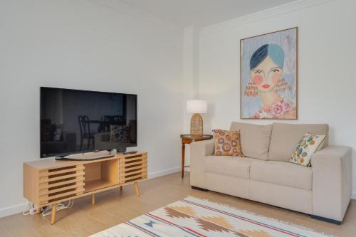 a living room with a couch and a tv at Maria Madalena in Madalena do Mar