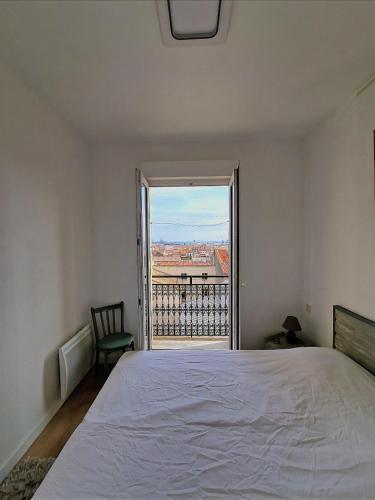 une chambre avec un lit et une grande fenêtre dans l'établissement Bel Appart Lumineux avec VUE MER en Centre-ville, à Sète