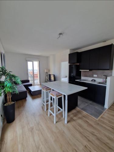 une cuisine et un salon avec une table et des chaises dans l'établissement Bel Appart Lumineux avec VUE MER en Centre-ville, à Sète