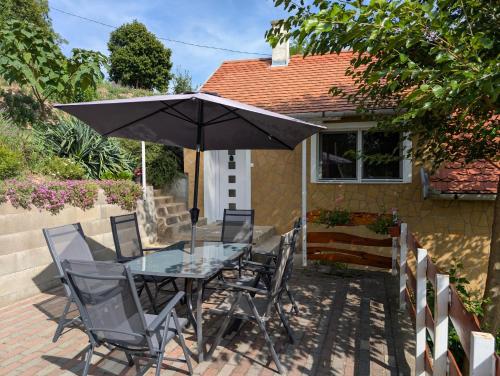 a table and chairs with an umbrella on a patio at Szőlőskert Vendégház in Baj