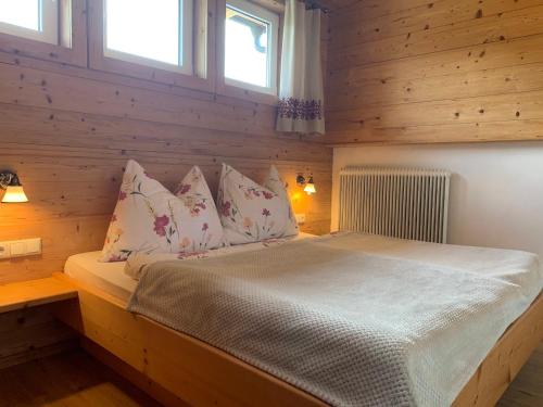 a bedroom with a bed in a wooden cabin at Aussermooserhof in Alpbach