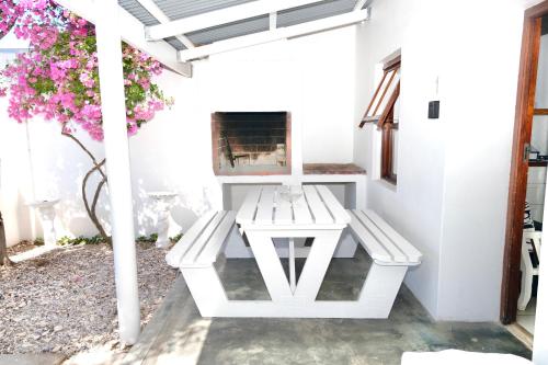 a white patio with a table and a fireplace at Paternoster Place in Paternoster
