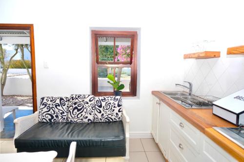 a kitchen with a black leather couch in a room at Paternoster Place in Paternoster