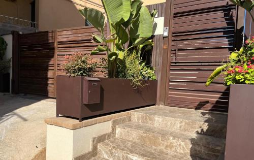 a wooden fence with potted plants on a staircase at Hera Rooms and Suites in Agrigento