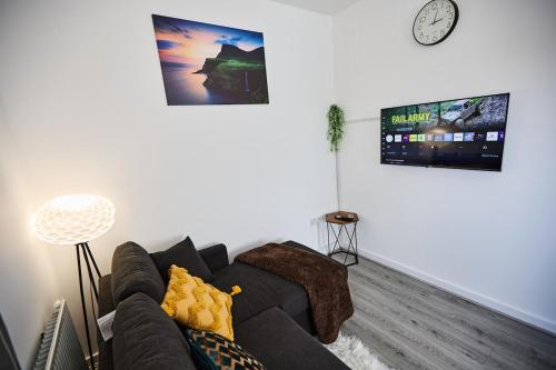 a living room with a couch and a tv at Ampee Guest Suite-Free Parking in Liverpool