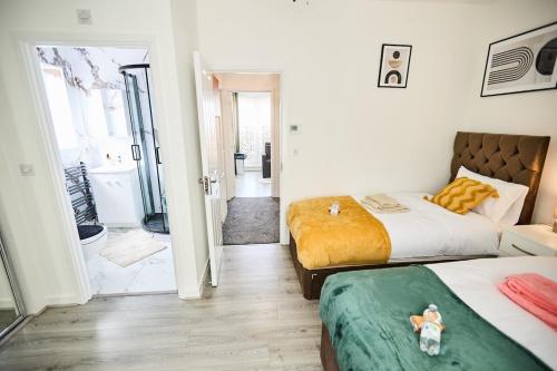 a bedroom with two beds and a bathroom at Ampee Guest Suite-Free Parking in Liverpool