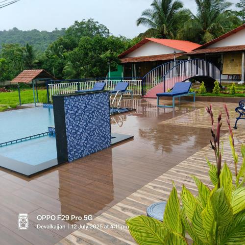 a resort with a pool and a house at De Orchid Resort in Agonda