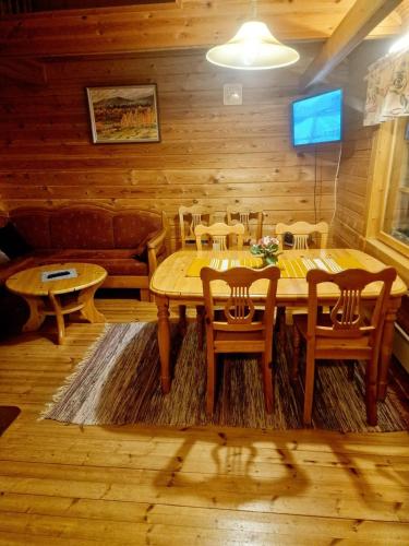 a wooden dining room with a table and chairs at Yllästölli B2 in Kittilä