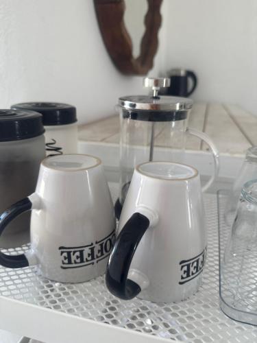 two coffee mugs sitting on top of a shelf at BY THE SEA ROOMS, AVLAKI in Porto Rafti
