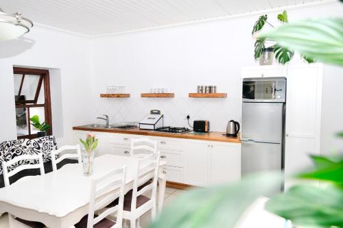 a kitchen with white cabinets and a table and chairs at Paternoster Place in Paternoster