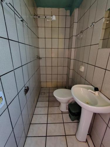 a bathroom with a toilet and a sink at Hotel Jardim Goiás in Rio Verde