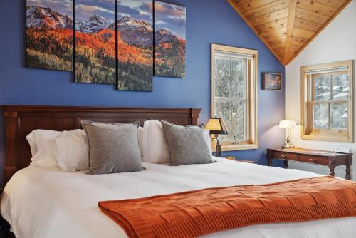 a bedroom with a large bed with a blue wall at Cozy Hillside Cottage Overlooking Main Street in Park City