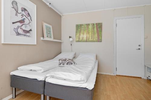 a bed in a room with white sheets at Brekstad Gjestehus AS in Brekstad