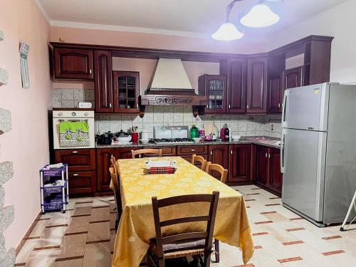 a kitchen with a table and a refrigerator at Villino Emma in Santadi