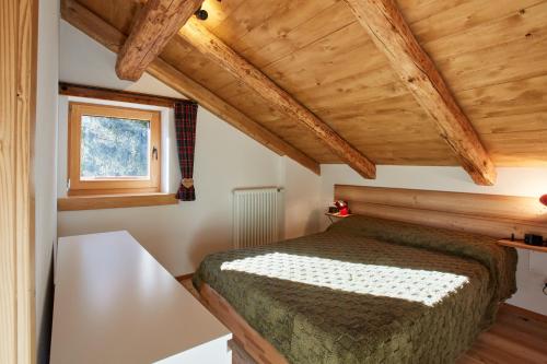 a bedroom with a bed in a room with wooden ceilings at Lioda Oak Alpine Charm in Vinigo