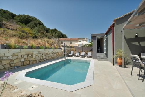 a swimming pool in the backyard of a house at Echoes of Prinos in Metókhion Yianítsari