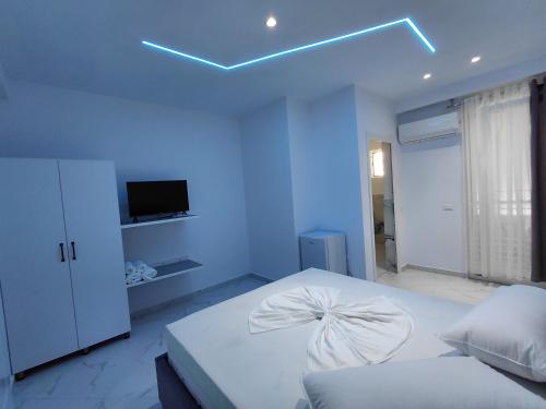 a bedroom with a white bed with a bow on it at Vila Kasemi in Fier